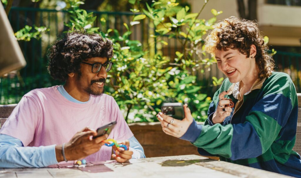 image of indian man and white girl looking at phone and smiling together