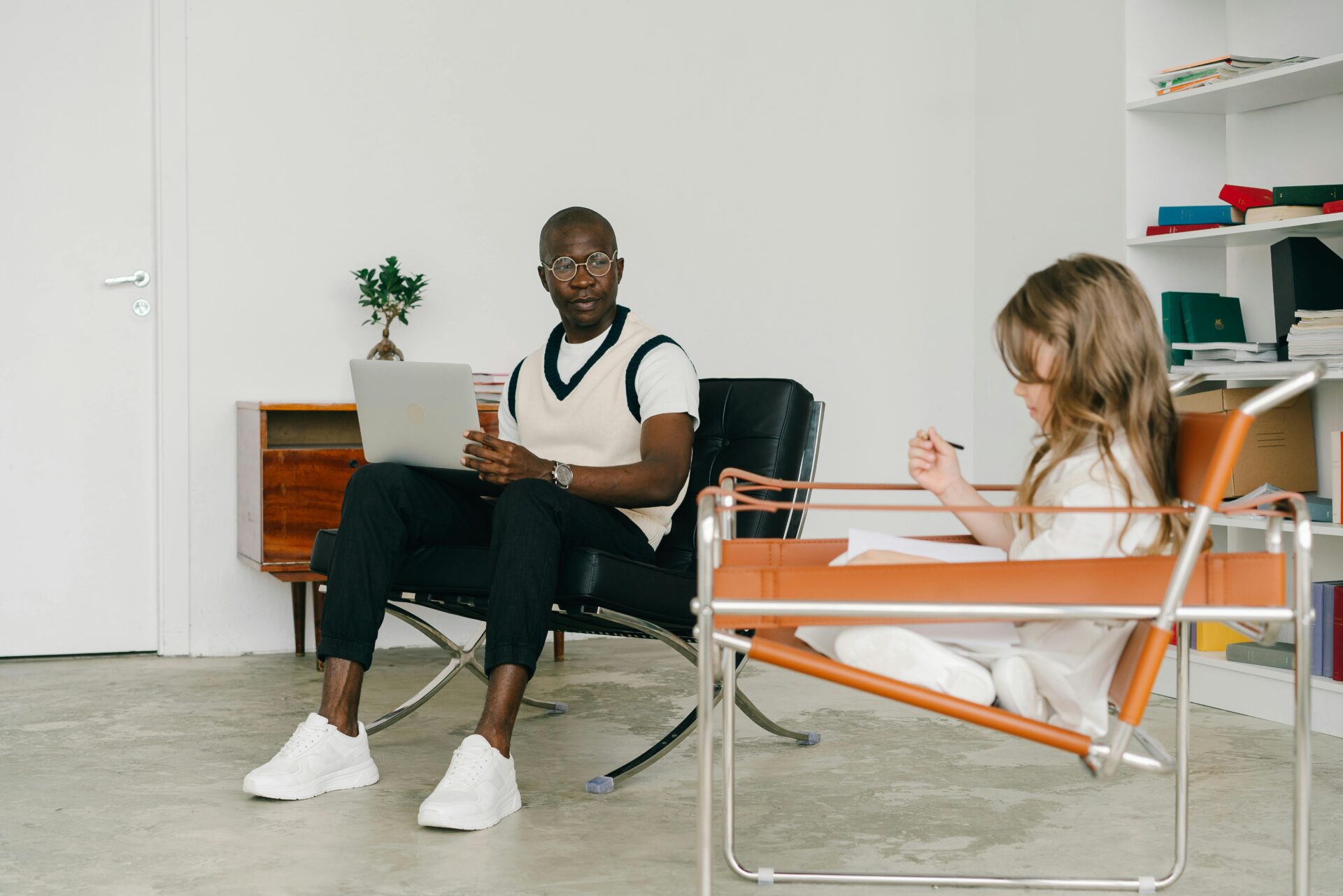 young girl sitting in a therapy room with therapist